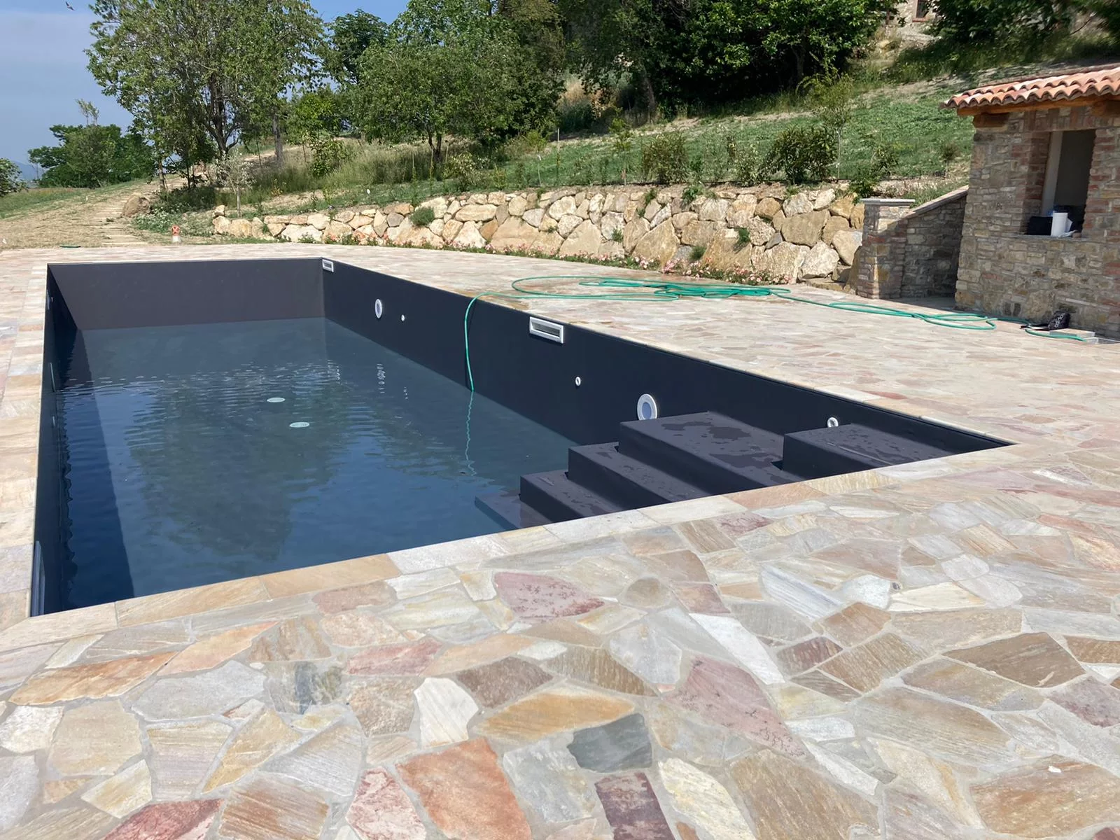 Piscina privata a skimmer, realizzata nelle colline piacentine, con rivestimento Alkorplan grigio antracite, realizzata su progetto - riempimento piscina 