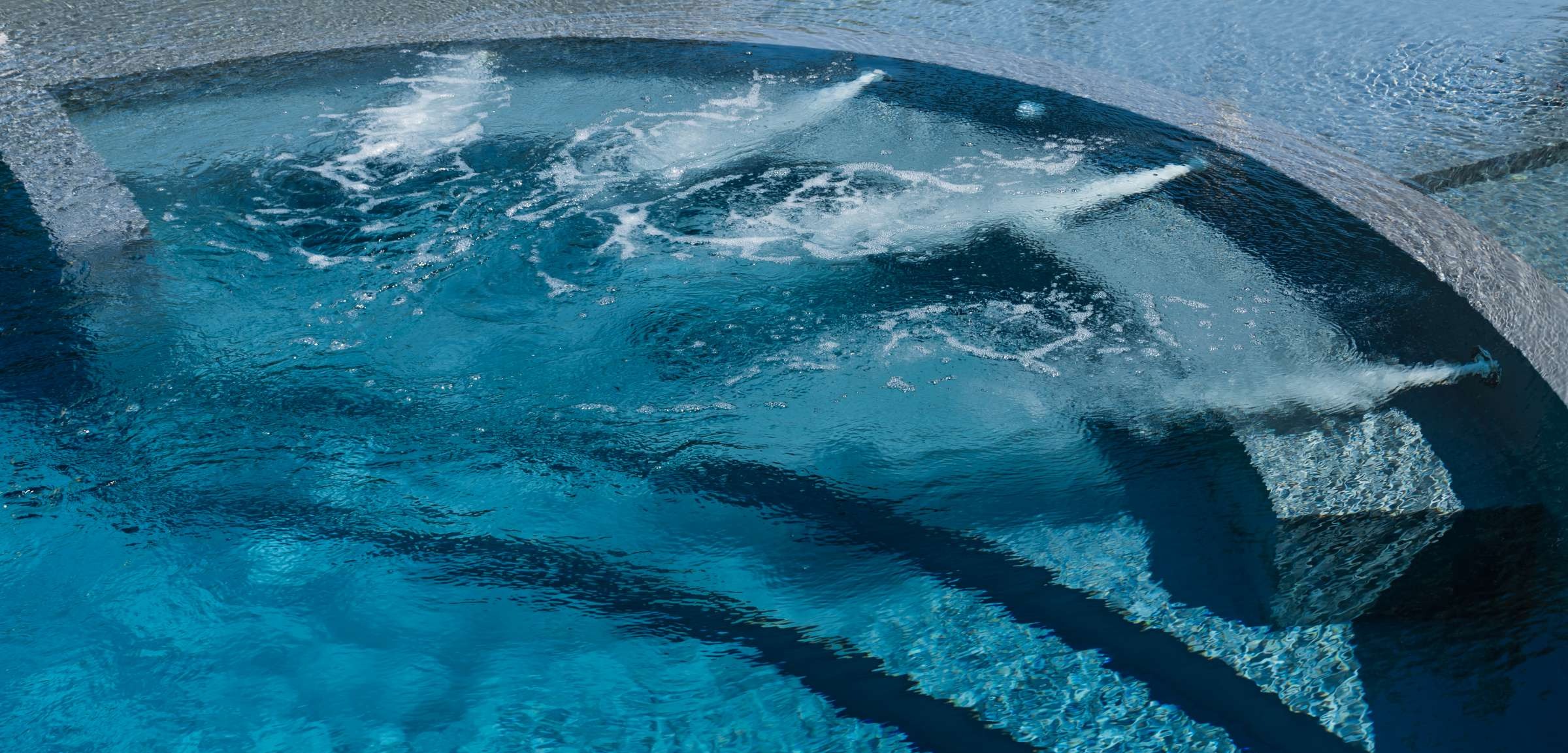 Piscina interrata con rivestimento grigio e panca idromassaggio - bocchette idromassaggio in acciaio inox Piscina interrata con rivestimento grigio e panca idromassaggio - bocchette idromassaggio in acciaio inox