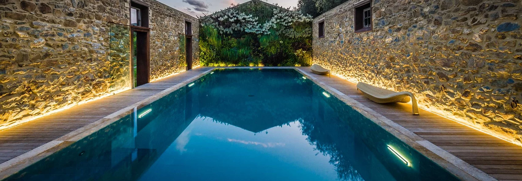 Piscina ricavata in una stalla ormai in disuso e priva del tetto, realizzata con tecnologia Myrtha e bordo a sfioro Trilogy - fari Blade Light subacquei a Led colorati accesi Piscina ricavata in una stalla ormai in disuso e priva del tetto, realizzata con tecnologia Myrtha e bordo a sfioro Trilogy - fari Blade Light subacquei a Led colorati accesi