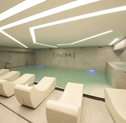 Piscina all'interno di una spa con giochi d'acqua e fari Led colorati Piscina all'interno di una spa con giochi d'acqua e fari Led colorati