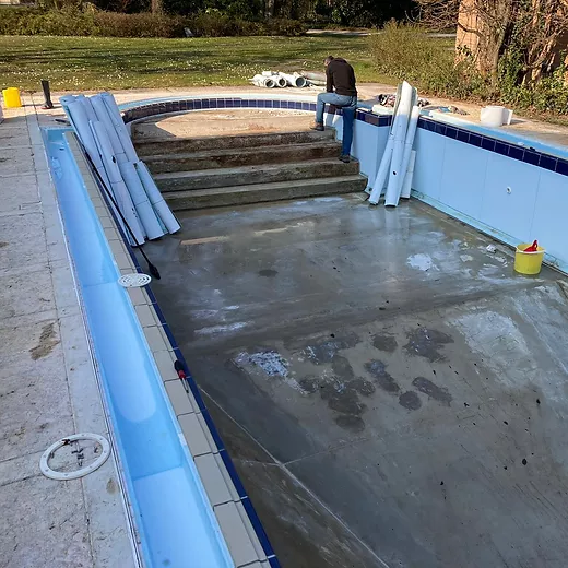 Piscina a sfioro con scala romana e cornice in mosaico, sottoposta a lavorazioni di ristrutturazione Piscina a sfioro con scala romana e cornice in mosaico, sottoposta a lavorazioni di ristrutturazione